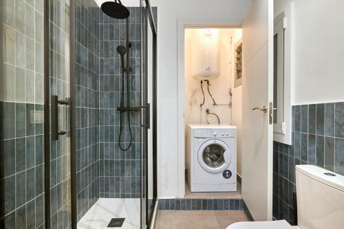 a bathroom with a shower and a washing machine at Ro Lively and bright apartment next to Blai st in Barcelona