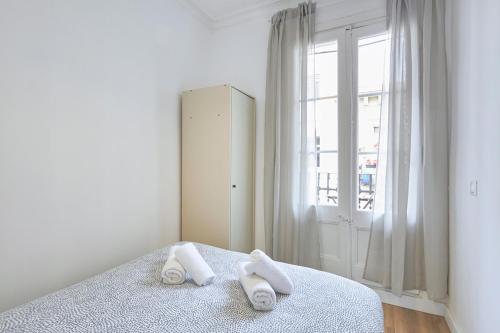 バルセロナにあるRo Lively and bright apartment next to Blai stのベッドルーム1室(ベッド1台、タオル2枚付)