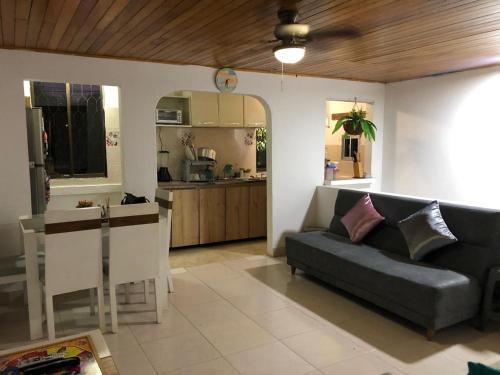 sala de estar con sofá y cocina en Acogedor Apartamento 2 alcobas cerca al mar, en Puerto Salgar