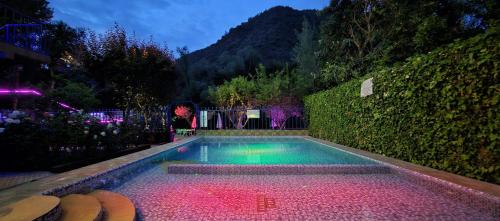 a swimming pool in a garden at night at Top Ourika in Aghbalou