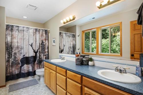 ein Badezimmer mit zwei Waschbecken und einem WC in der Unterkunft Iron Mountain - Spacious Secluded Lodge with Hot Tub & Game Room in Sandy