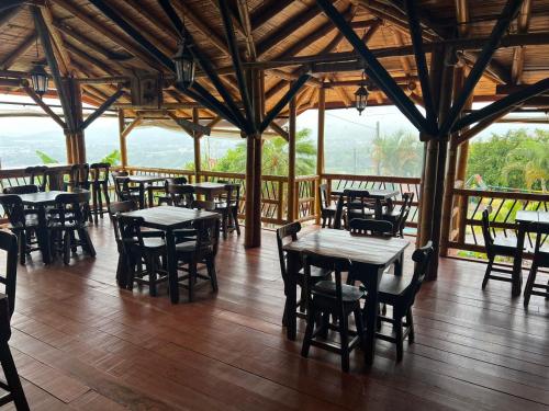 a restaurant with tables and chairs in a building at Eco Hotel La Selecta Campestre in Pereira