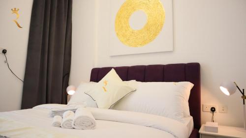 een slaapkamer met een bed met witte kussens bij Urban Oasis Retreat Transit - 2BR duplex in Abu Dhabi