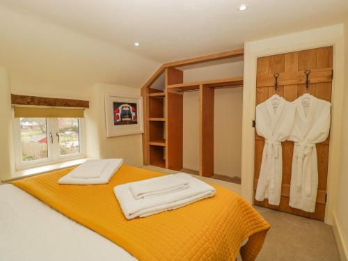 a bedroom with an orange bed and a closet at Forever Home in Honiton