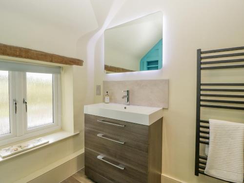 a bathroom with a sink and a mirror at Forever Home in Honiton