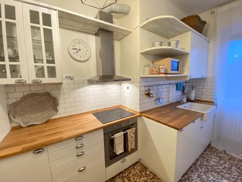 a kitchen with white cabinets and a stove top oven at Contrada Valle in Oleggio