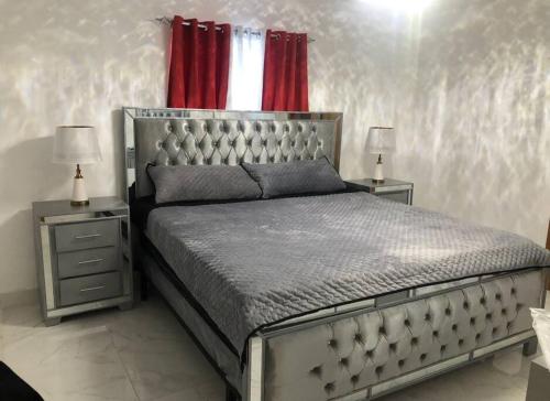 um quarto com uma cama grande e 2 mesas de cabeceira em Acogedor Sweet Apartament em Santiago de los Caballeros