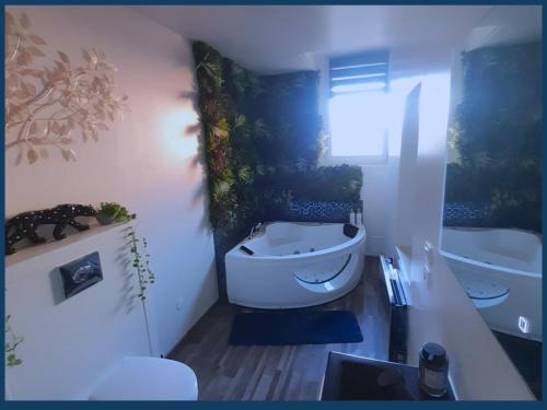 La salle de bains est pourvue d'une baignoire, de toilettes et d'un lavabo. dans l'établissement 01 Le rêve des 1000 bulles By Fanny S, à Saint-Quentin