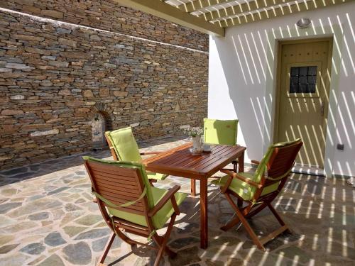 a wooden table and chairs on a patio at Anchorage Andros Villa in Andros