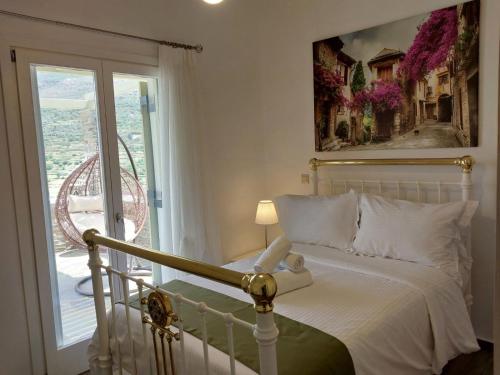 a bedroom with a bed and a window with a view at Anchorage Andros Villa in Andros