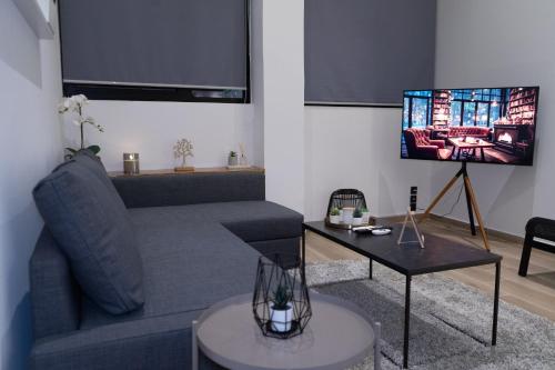 a living room with a couch and a flat screen tv at CozyLoft 2 in Patra