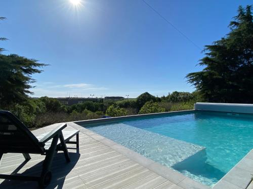 a chair sitting on a deck next to a swimming pool at House of green leaves in Chelreira
