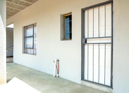 Habitación con ventanas y pared blanca. en White Oak Place, en Katoen