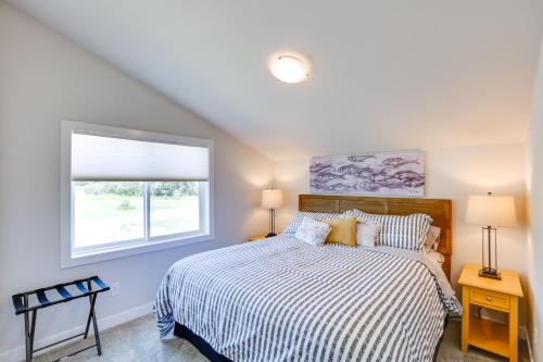 um quarto com uma cama com um edredão listrado e uma janela em Red Lodge Retreat with Creek Access and Fire Pit! em Red Lodge