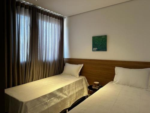 a bedroom with two beds and a window at PARK SUL - Edifício Essence - 4 in Brasilia