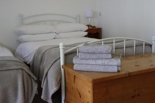 a bedroom with a bed with towels on a table at Malthouse Farm Cottage Studio in Dilhorne