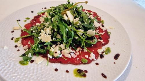 a white plate with a salad on a table at Hôtel Saint Jacques in Thorigné-sur-Dué