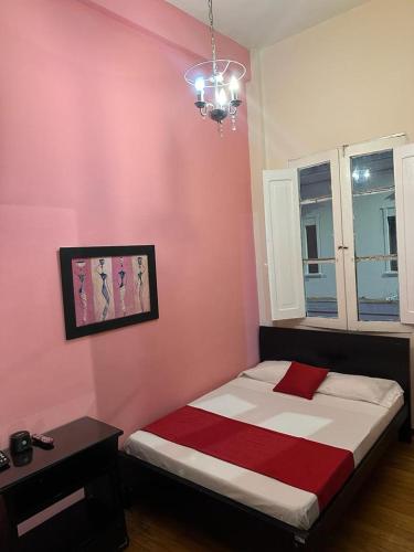 ein Schlafzimmer mit einem Bett und einer rosa Wand in der Unterkunft Boutique del cafe in Manizales