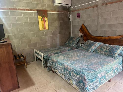 a bedroom with two beds and a tv in it at Cabañas Los Frutales in Santa María