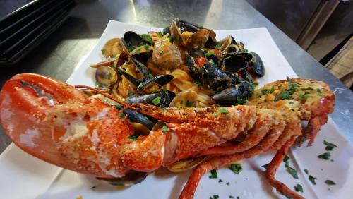 a plate of food with a lobster and mussels at Hôtel Saint Jacques in Thorigné-sur-Dué