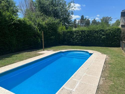una gran piscina azul en un patio en Cabañas Los Frutales en Santa María