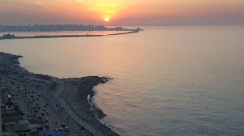 una vista aerea di una spiaggia con un tramonto di لعشاق الفيو المفتوح بانوراما للبحر مباشر ad Alessandria d'Egitto