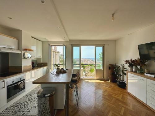 une cuisine avec une table et une vue sur l'océan dans l'établissement Charmant T2 - vue imprenable sur Marseille, à Marseille
