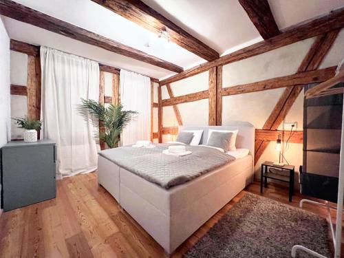 una camera con letto bianco in una stanza con soffitti in legno di BackHome - Fantastische Lage, SmartTV, Netflix, 50qm, 24h Checkin - Apartment 5 a Schwäbisch Hall