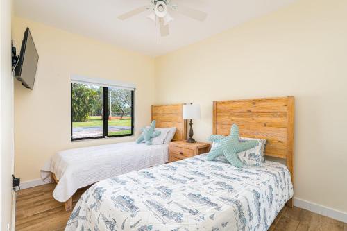 a bedroom with two beds and a window at Renovated Multi Family 3 Bedroom with a Pool in Dania Beach