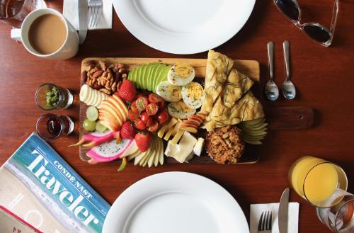 a wooden table with a plate of food on a cutting board at The Diplomat Boutique Hotel in Mérida