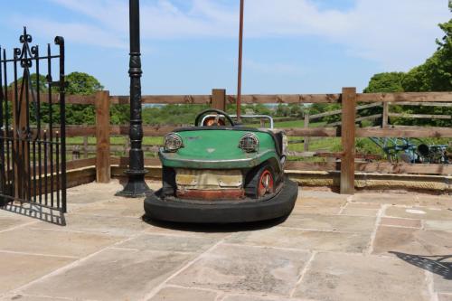 a small green car in front of a fence at Malthouse Farm Cottage Studio in Dilhorne
