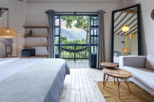 a bedroom with a bed and a couch and a window at Hotel Plantación in Jardin