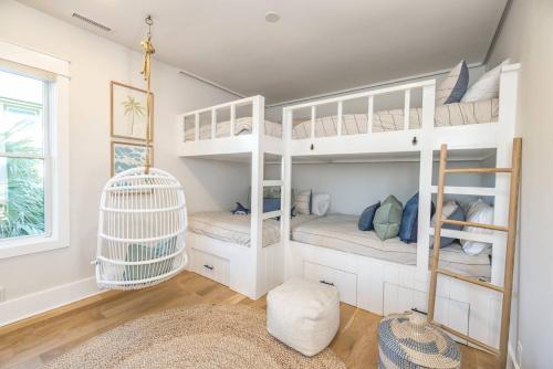 a room with white bunk beds and a window at Oceans 12 in Wrightsville Beach