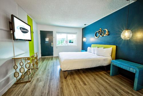 um quarto com uma cama e uma parede azul em Downtowner Boutique Hotel em Las Vegas