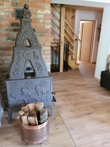 a fireplace in a living room with a basket of logs at Stary Dom z Piwnicą in Krynica Zdrój