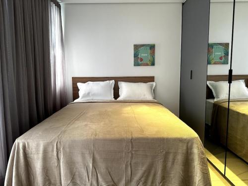 a bedroom with a large bed with white pillows at PARK SUL - Edifício Essence - 7 in Brasília