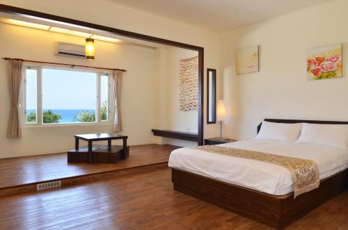 a bedroom with a bed and a large window at The Blue Lagoon B&B in Fengbin