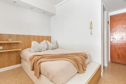 - une chambre avec un grand lit et une tête de lit en bois dans l'établissement Boutique Apartament Torreón, à Mar del Plata