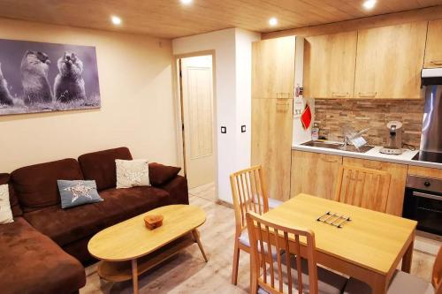 a living room with a couch and a table at LE PICOULET : Appartement tout confort Coeur de village( 5/7 ) in Allos