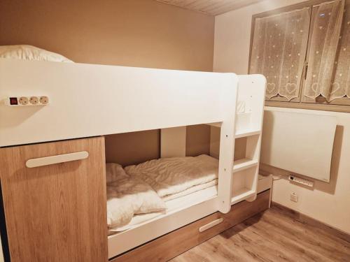 a white bunk bed in a small room at LE PICOULET : Appartement tout confort Coeur de village( 5/7 ) in Allos