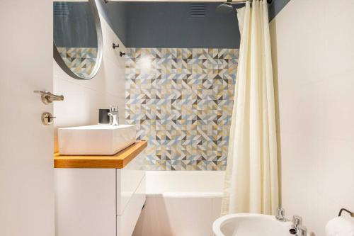 La salle de bains est pourvue d'un lavabo et d'un rideau de douche. dans l'établissement Boutique Apartament Torreón, à Mar del Plata