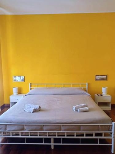 a bedroom with a bed with a yellow wall at Luminoso appartamento - Castelli in Santa Maria delle Mole