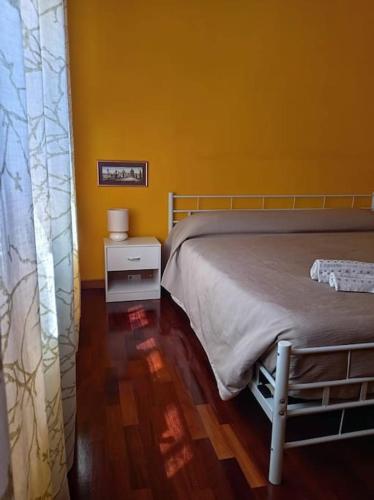 a bedroom with a bed and a yellow wall at Luminoso appartamento - Castelli in Santa Maria delle Mole