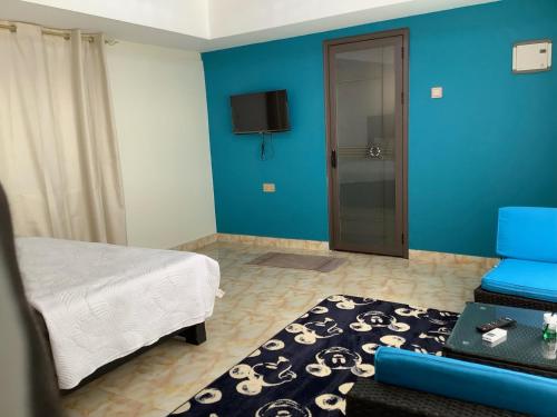 1 dormitorio con cama y pared azul en HERITAGE LODGE & EVENT CENTER, en Ada