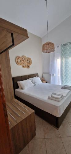 a bedroom with a large bed and a chair at Slanchev Apartment in Ofrínion