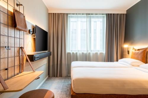 um quarto de hotel com duas camas e uma televisão em Moxy Berlin Airport em Schönefeld