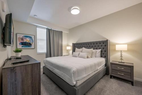 una camera da letto con un letto grande e una televisione di Superb Spacious Condo Prime Resort a Kissimmee
