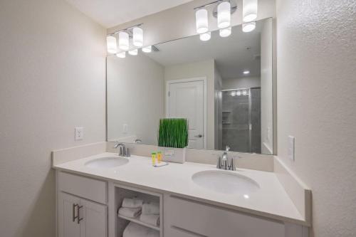 un bagno con due lavandini e un grande specchio di Superb Spacious Condo Prime Resort a Kissimmee