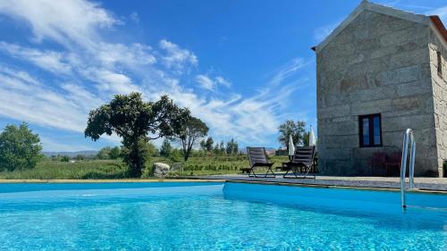 Villa con piscina frente a un edificio en Quinta da Cumieira Nova, en Seia