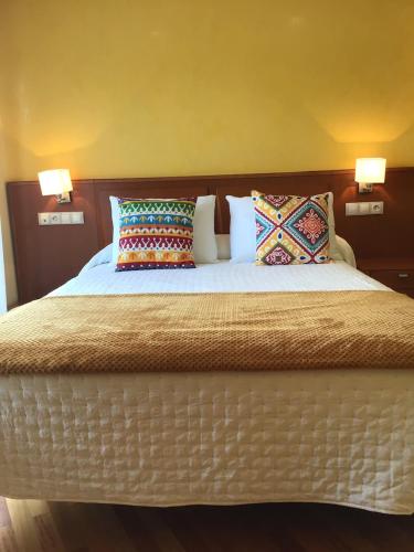 a large bed with two pillows on top of it at Complexo Alameda in Viveiro